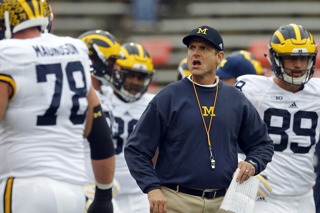Michigan head coach Jim Harbaugh watches his players warm up before an NCAA college football game against Maryland, Saturday, Oct. 3, 2015, in College Park, Md. (AP Photo/Patrick Semansky)