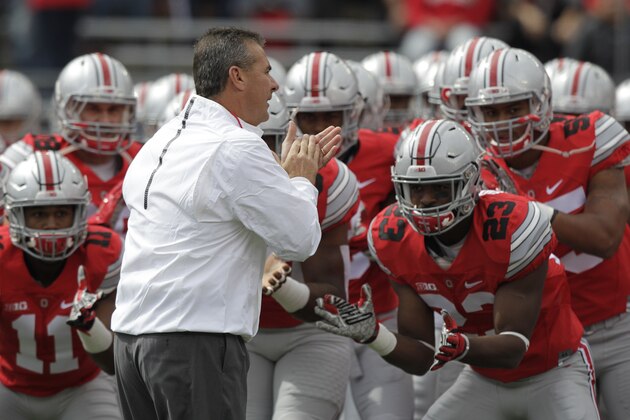 Ohio State head coach Urban Meyer works with his team during warm-ups before an NCAA college football game against Hawaii, Saturday, Sept. 12, 2015, in Columbus, Ohio. (AP Photo/Jay LaPrete)