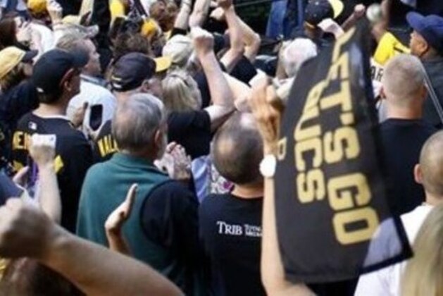 Pittsburgh Mayor Bill Peduto wears a jersey with the number of Pittsburgh Pirates' Jung-ho Kang as he talks to fans during a lunch-time rally to show support for the Pirates upcoming wild-card playoff baseball game against the Chicago Cubs, in Pittsburgh, Tuesday, Oct. 6, 2015. Peduto said he was told that Kang, who's season ended when he was injured playing against the Cubs on Sept. 17, would be on the field during the team introduction Wednesday. (AP Photo/Keith Srakocic)