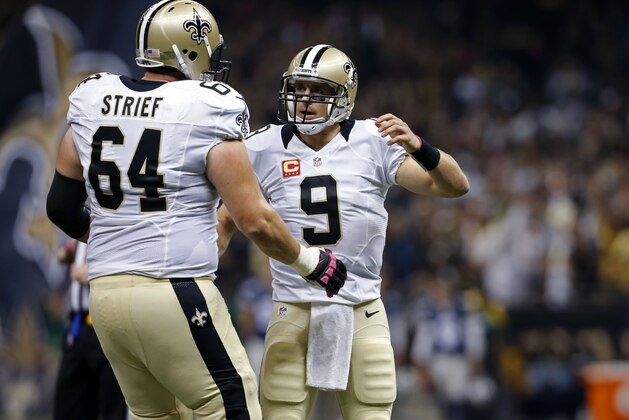 New Orleans Saints quarterback Drew Brees (9) celebrates his 5,000 career reception with tackle Zach Strief (64) after a touchdown pass to tight end Josh Hill in the first half of an NFL football game in New Orleans, Sunday, Oct. 4, 2015. (AP Photo/Jonathan Bachman)