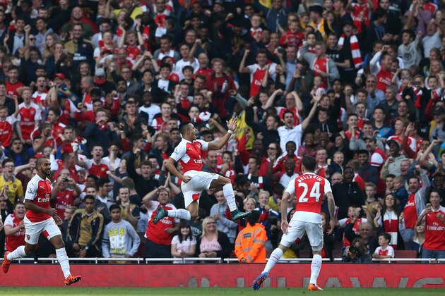 Arsenal's Chilean striker Alexis Sanchez (C) celebrates scoring his goal with team mates Arsenal's German midfielder Arsenal's English midfielder Theo Walcott (L) during the English Premier League football match between Arsenal and Manchester United at the Emirates Stadium in London on October 4, 2015.    AFP PHOTO / JUSTIN TALLIS

RESTRICTED TO EDITORIAL USE. No use with unauthorised audio, video, data, fixture lists, club/league logos or 'live' services. Online in-match use limited to 45 images, no video emulation. No use in betting, games or single club/league/player publications.        (Photo credit should read JUSTIN TALLIS/AFP/Getty Images)
