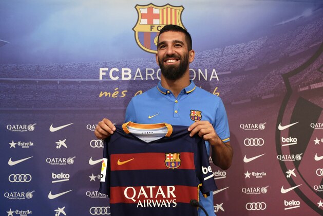 FC Barcelona's new signing Arda Turan poses for the media with his jersey during his official presentation at the Camp Nou stadium in Barcelona, Spain, Friday, July 10, 2015. The European champions announced a five-year deal for the 28-year-old Turkey midfielder. Barcelona made the signing despite currently being without a permanent president or executive board members, who resigned under club bylaws before elections on July 18. (AP Photo/Manu Fernandez)