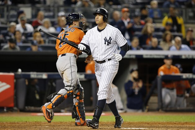 New York Yankees designated hitter Alex Rodriguez walks to the dugout as Houston Astros catcher Jason Castro (15) returns the ball to the pitcher after Rodriguez struck out in the ninth inning of the American League wild card baseball game at Yankee Stadium in New York, Tuesday, Oct. 6, 2015.  (AP Photo/Kathy Willens)