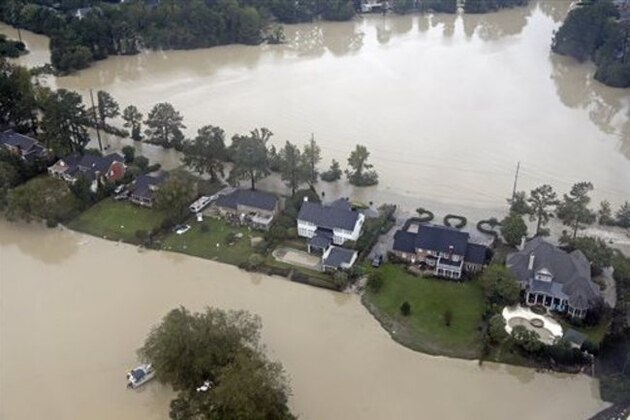 Floodwaters close in on homes on a small piece of land on Lake Katherine in Columbia, S.C., Monday, Oct. 5, 2015. After a week of steady rain, the showers tapered off Monday and an inundated South Carolina turned to surveying a road system shredded by historic flooding. (AP Photo/Chuck Burton)