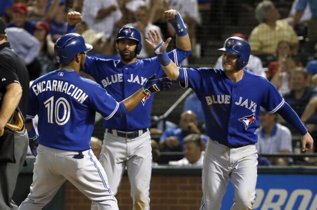 Home plate umpire Ed Hickox stands by the plate as Toronto Blue Jays' Edwin Encarnacion (10) is congratulated by Jose Bautista, center, and Josh Donaldson, right, following Incarnation's grand slam during the sixth inning of a baseball game against the Texas Rangers Wednesday, Aug. 26, 2015, in Arlington, Texas. The shot also scored Troy Tulowitzki. (AP Photo/Tony Gutierrez)