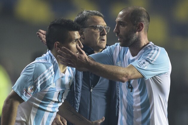 Argentina's forward Sergio Aguero (L) celebrates with Argentina's defender Pablo Zabaleta (R) and Argentina's coach Gerardo Martino  after scoring against Paraguay during their Copa America semifinal football match in Concepcion, Chile on June 30, 2015.  AFP PHOTO / JUAN MABROMATA        (Photo credit should read JUAN MABROMATA/AFP/Getty Images)