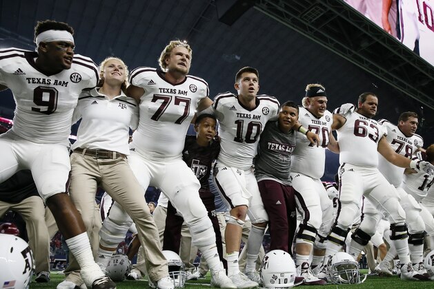 Texas A&M players gather with quarterback quarterback Kyle Allen (10) to sing their school song and celebrate their 28-21 overtime win in an NCAA college football game against Arkansas on Saturday, Sept. 26, 2015, in Arlington, Texas. (AP Photo/Tony Gutierrez)