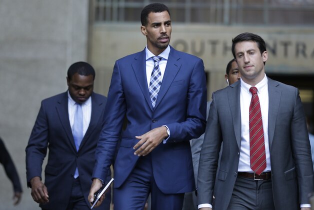 Thabo Sefolosha, center, leaves criminal court in New York, Wednesday, Oct. 7, 2015. The professional basketball player was about to give a handout to a man asking for money when police officers took him to the ground and arrested him, a former teammate testified Wednesday. (AP Photo/Seth Wenig)