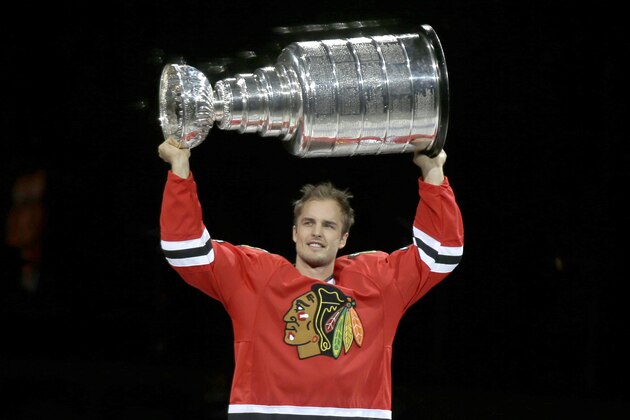 Chicago Blackhawks' Niklas Hjalmarsson carries the Stanley Cup to center ice during a Stanley Cup championship banner raising ceremony before an NHL hockey game between the Blackhawks and the New York Rangers, Wednesday, Oct. 7, 2015, in Chicago. (AP Photo/Nam Y. Huh)