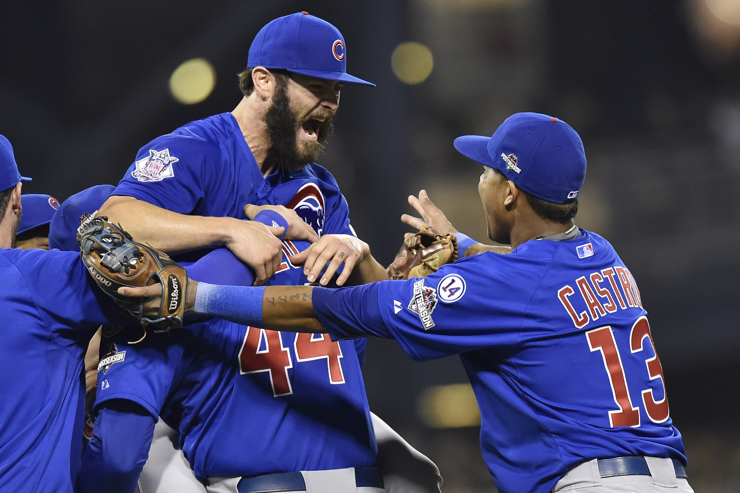 Chicago Cubs first baseman Anthony Rizzo, (44), holds Chicago Cubs starting pitcher Jake Arrieta as shortstop Starlin Castro (13) joins in the celebration after they defeated the Pittsburgh Pirates in the National League wild card baseball game 4-0, Wednesday, Oct. 7, 2015, in Pittsburgh. The Cubs advance to play the St. Louis Cardinals in the National League Division Series. (AP Photo/Don Wright)