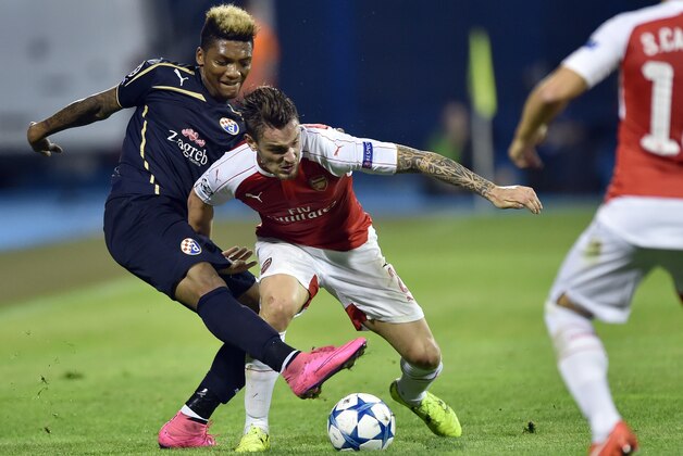 Arsenal's French defender Mathieu Debuchy (C) vies with Dinamo Zagreb's Chilean forward Junior Fernandes (L) during the UEFA Champions League Group F football match between GNK Dinamo Zagreb and Arsenal FC at Maksimir Stadium in Zagreb on September 16, 2015.  AFP PHOTO / ANDREJ ISAKOVIC        (Photo credit should read ANDREJ ISAKOVIC/AFP/Getty Images)