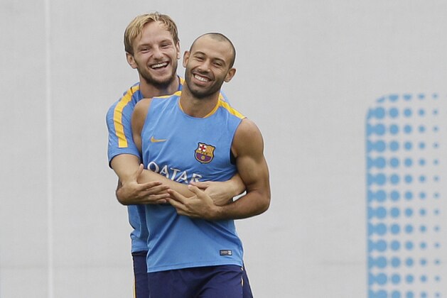 FC Barcelona's Ivan Rakitic, left, embraces to his teammate Javier Mascherano during a training session one day ahead a Spanish Supercup first leg soccer match against Athletic Bilbao at the Sports Center FC Barcelona Joan Gamper in San Joan Despi, Spain, Thursday, Aug. 13, 2015. (AP Photo/Manu Fernandez)