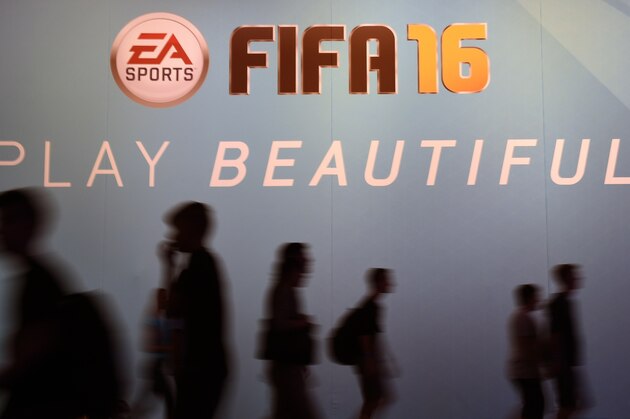Visitors walk past an ad for the FIFA 16 football game at the Gamescom fair in Cologne, western Germany on August 7, 2015. The trade fair for interactive games is running until August 9, 2014. PHOTO / PATRIK STOLLARZ        (Photo credit should read PATRIK STOLLARZ/AFP/Getty Images)