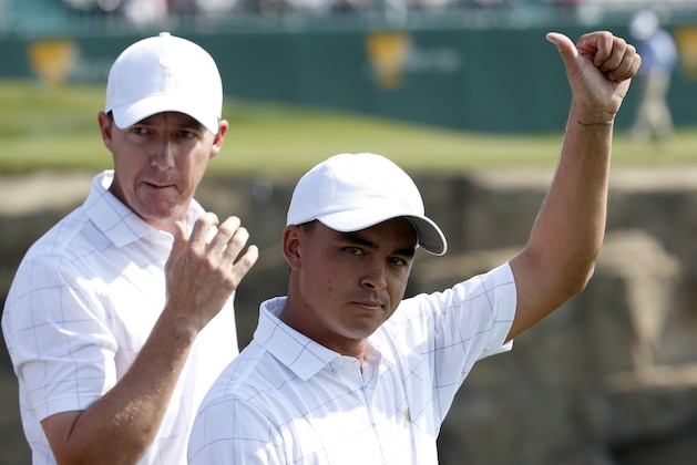 United States' Rickie Fowler gestures to the crowd as he walks with teammate Jimmy Walker during their foursome match at the Presidents Cup golf tournament at the Jack Nicklaus Golf Club Korea, in Incheon, South Korea, Thursday, Oct. 8, 2015.(AP Photo/Lee Jin-man)