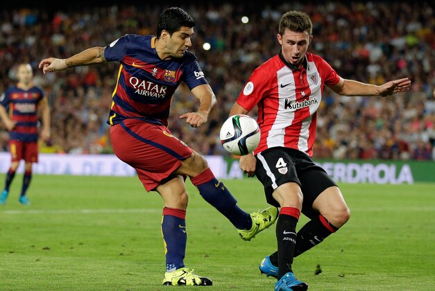 Athletic Bilbao's Aymeric Laporte, right, blocks a shot from Barcelona's Luis Suarez during a second leg Spanish Super Cup soccer match between FC Barcelona and Athletic Bilbao at the Camp Nou stadium in Barcelona, Spain, Monday, Aug.17, 2015. (AP Photo/Manu Fernandez)