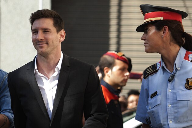 Barcelona F.C. soccer player Lionel Messi, left,  arrives at a court to answer questions in a tax fraud case,  in Gava, near Barcelona, Spain, Friday, Sept. 27, 2013. Barcelona star Lionel Messi and his father are appearing before a Spanish judge to answer questions in a tax fraud case. A complaint lodged by a Spanish state prosecutor in June said Messi and his father tried to conceal earnings from the player's image rights. The complaint alleged the Argentina international owed 4 million euros ($5.3 million) in back taxes from 2007, 2008 and 2009. (AP Photo/Paco Serinelli)