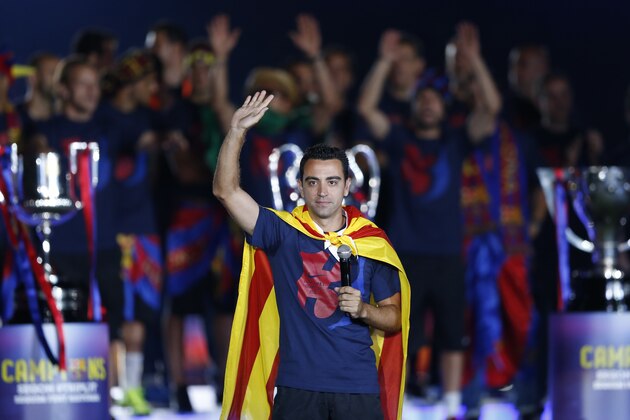 Barcelona's Xavi Hernandez waves to the fans during celebrations at the Camp Nou stadium in Barcelona, Spain Sunday June 7, 2015 after winning the Champions League final soccer match Saturday by beating Juventus Turin 3-1. Barcelona won the triple this season winning the Spanish League title, the Copa del Rey and the Champions League. (AP Photo/Manu Fernandez)