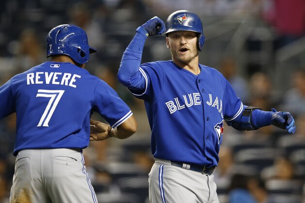 Toronto Blue Jays Ben Revere (7) celebrates with teammate Josh Donaldson after scoring on Donaldson's first-inning, two-run, home run off New York Yankees starting pitcher Luis Severino in a baseball game at Yankee Stadium in New York, Friday, Sept. 11, 2015.  (AP Photo/Kathy Willens)