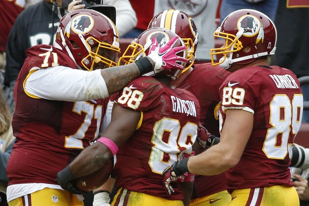 Washington Redskins wide receiver Pierre Garcon (88) is congratulated by teammates tackle Trent Williams (71) and tight end Derek Carrier (89) after scoring the winning touchdown during the second half of an NFL football game in Landover, Md., Sunday, Oct. 4, 2015. The Redskins defeated the Eagles 23-20. (AP Photo/Alex Brandon)