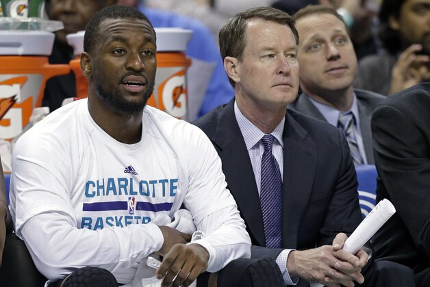 Charlotte Hornets assistant coach Mark Price, right, watches the action with Kemba Walker, left, during the first half of an NBA basketball game against the Brooklyn Nets in Charlotte, N.C., Wednesday, March 25, 2015. A person familiar with the situation says the Charlotte 49ers have hired Price to become their new men's basketball coach. The person spoke to The Associated Press on Wednesday, March 25, 2015, on condition of anonymity because the hire has not been publicly announced. (AP Photo/Chuck Burton)