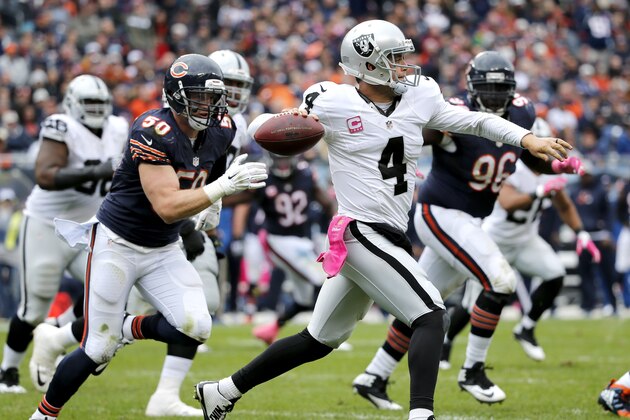 Oakland Raiders quarterback Derek Carr (4) scrambles and throws under pressure from Chicago Bears inside linebacker Shea McClellin (50), during the second half of an NFL football game, Sunday, Oct. 4, 2015, in Chicago. (AP Photo/Charles Rex Arbogast)