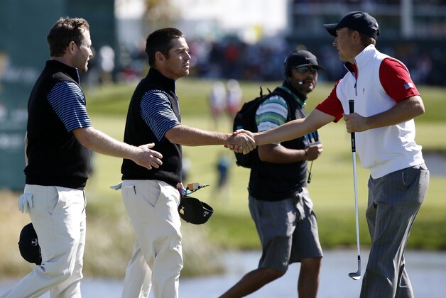 United States' Jordan Spieth, right, congratulates International team player's Louis Oosthuizen of South Africa and his teammate Branden Grace, left, on their during their 4&3 four ball win at the Presidents Cup golf tournament at the Jack Nicklaus Golf Club Korea, in Incheon, South Korea, Friday, Oct. 9, 2015.(AP Photo/Lee Jin-man)