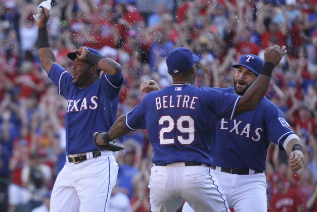 Texas Rangers Hanser Alberto, left, Adrian Beltre (29) and Mitch Moreland (18) celebrate on the field after the final out of the baseball game against the Los Angeles Angels in Arlington, Texas, Sunday, Oct. 4, 2015. (AP Photo/LM Otero)