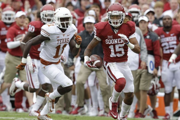 Oklahoma cornerback Zack Sanchez (15) intercepts a pass in front of Texas wide receiver Jacorey Warrick and runs it in for a touchdown during the first half of an NCAA college football game at the Cotton Bowl, Saturday, Oct. 11, 2014, in Dallas. (AP Photo/LM Otero)