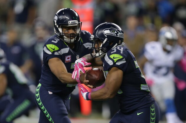 Seattle Seahawks quarterback Russell Wilson, left, hands off to running back Thomas Rawls in the second half of an NFL football game against the Detroit Lions, Monday, Oct. 5, 2015, in Seattle. (AP Photo/Scott Eklund)