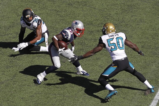 Jacksonville Jaguars cornerback Demetrius McCray (35)  and outside linebacker Telvin Smith (50) attempt to tackle New England Patriots running back Dion Lewis (33) during the first quarter of an NFL football game, Sunday, Sept. 27, 2015, in Foxborough, Mass. (AP Photo/Stew Milne)