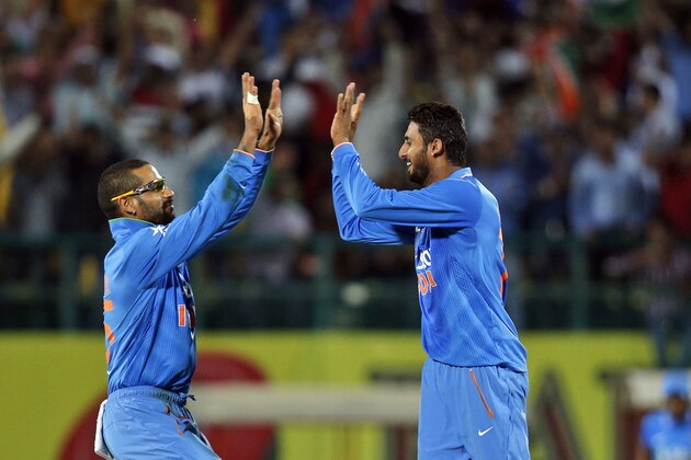 India's Sreenath Aravind, right, and Shikhar Dhawan celebrate the dismissal of South Africa's captain Faf du Plessis during their first Twenty20 cricket match in Dharmsala, India, Friday, Oct. 2, 2015. (AP Photo/Tsering Topgyal)