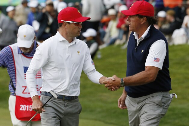 United States' Phil Mickelson shakes hands with his partner United States' Zach Johnson after their 3&2 four ball match win at the Presidents Cup golf tournament at the Jack Nicklaus Golf Club Korea, in Incheon, South Korea, Saturday, Oct. 10, 2015.(AP Photo/Lee Jin-man)