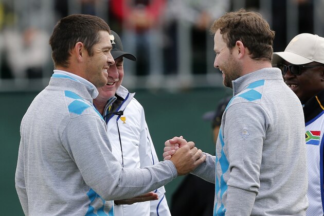 International team player Branden Grace, right, of South Africa shakes hands with his partner and compatriot Louis Oosthuizen after they defeated United States' Patrick Reed and Rickie Fowler 3&2 in their foursome match at the Presidents Cup golf tournament at the Jack Nicklaus Golf Club Korea, in Incheon, South Korea, Saturday, Oct. 10, 2015.(AP Photo/Woohae Cho)