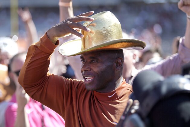 Texas head coach Charlie Strong puts on the Golden Hat as the Longhorns celebrate their 24-17 win over Oklahoma in an NCAA college football game, Saturday, Oct. 10, 2015, in Dallas. (AP Photo/LM Otero)
