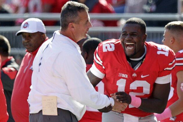 Ohio State head coach Urban Meyer, left, jokes around with quarterback Cardale Jones during the fourth quarter of an NCAA college football game against Maryland Saturday, Oct. 10, 2015, in Columbus, Ohio. Ohio State beat Maryland 49-28. (AP Photo/Jay LaPrete)