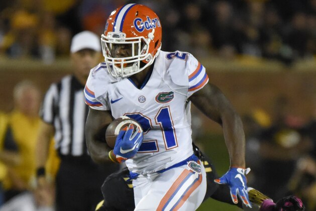 COLUMBIA, MO - OCTOBER 10:  Running back Kelvin Taylor #21 of the Florida Gators looks for running room against Aarion Penton #11 of the Missouri Tigers in the first quarter at Memorial Stadium on October 10, 2015 in Columbia, Missouri.  (Photo by Ed Zurga/Getty Images)