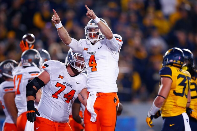 MORGANTOWN, WV - OCTOBER 10: J.W. Walsh #4 of the Oklahoma State Cowboys celebrates after throwing a pass for a touchdown in the third quarter against the West Virginia Mountaineers during the game at Mountaineer Field on October 10, 2015 in Morgantown, West Virginia.  (Photo by Jared Wickerham/Getty Images)