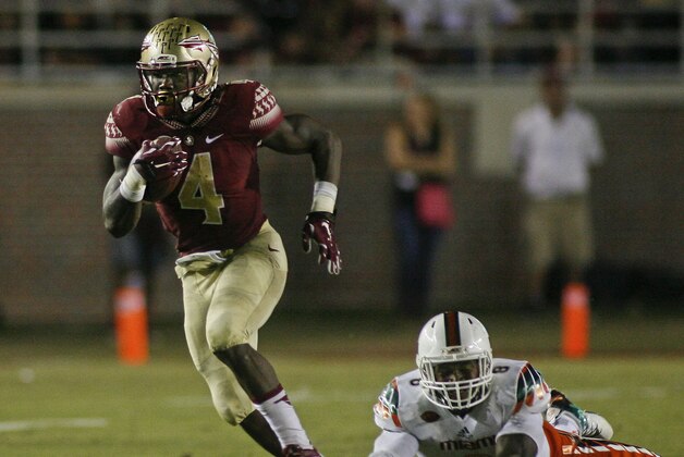 Oct 10, 2015; Tallahassee, FL, USA; Florida State Seminoles running back Dalvin Cook (4) gets past Miami Hurricanes defensive lineman Al-Quadin Muhammad (8) for a long gain in the second quarter of their game at Doak Campbell Stadium. Mandatory Credit: Phil Sears-USA TODAY Sports