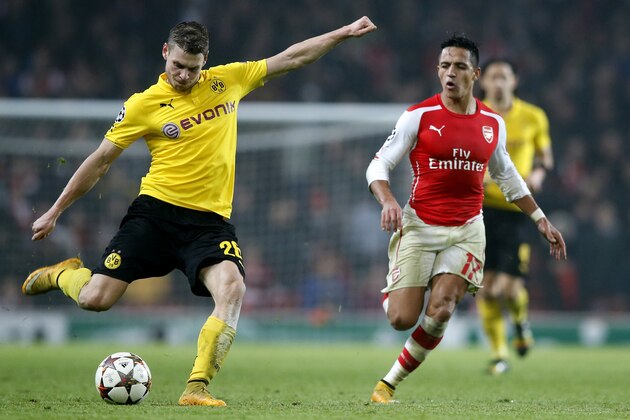 Dortmund's Lukasz Piszczek, left, kicks the ball past Arsenal's Alexis Sanchez during the Champions League group D soccer match between Arsenal and Borussia Dortmund at the Emirates stadium in London, Wednesday, Nov. 26, 2014. (AP Photo/Alastair Grant)