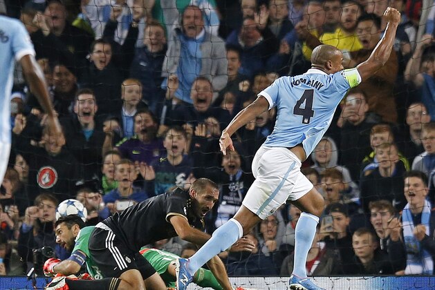 Manchester City's Vincent Kompany, right, celebrates after his header hit Juventus' Giorgio Chiellini, centre, for an own goal during the Champions League group D soccer match between Manchester City and Juventus at the Etihad Stadium, Manchester, England, Tuesday, Sept. 15, 2015. (AP Photo/Jon Super)
