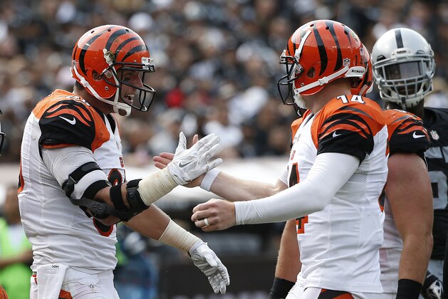 Cincinnati Bengals tight end Tyler Eifert (85) and quarterback Andy Dalton (14) celebrate after connecting on a 13-yard touchdown pass against the Oakland Raiders during the first half of an NFL football game in Oakland, Calif., Sunday, Sept. 13, 2015. (AP Photo/Tony Avelar)