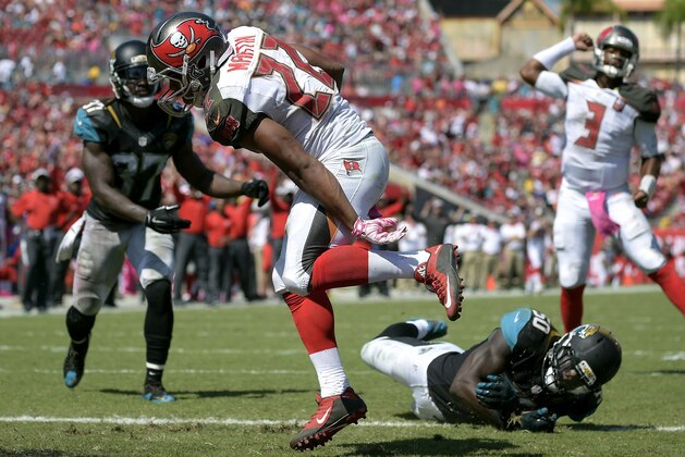 Tampa Bay Buccaneers running back Doug Martin (22) runs into the end zone after getting past Jacksonville Jaguars strong safety Johnathan Cyprien (37) and outside linebacker Telvin Smith (50) on a 1-yard touchdown run during the second quarter of an NFL football game Sunday, Oct. 11, 2015, in Tampa, Fla. (AP Photo/Phelan M. Ebenhack)