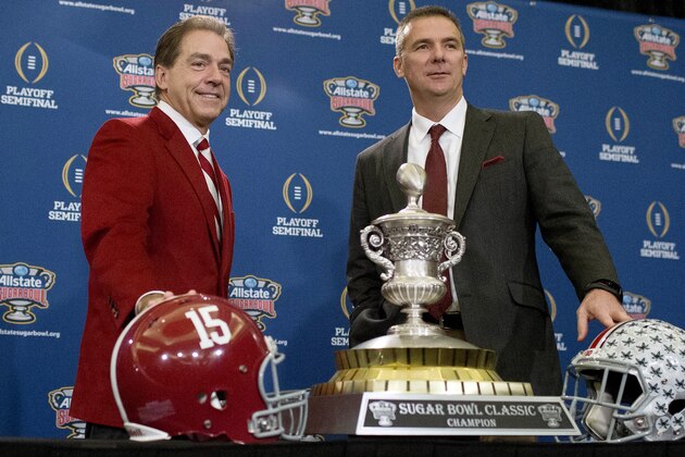 Alabama coach Nick Saban, left, and Ohio State coach Urban Meyer pose with the Sugar Bowl Classic trophy during a press conference at the Marriott downtown convention center in New Orleans, Wednesday, Dec. 31, 2014. Alabama is slated to square off against Ohio State in the Sugar Bowl NCAA college football playoff semifinal on New Year's Day. (AP Photo/Brynn Anderson)