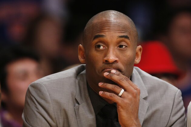 Los Angeles Lakers' Kobe Bryant, who is injured, sits on the bench in a suit against the New York Knicks during the first half of an NBA Basketball game, Thursday, March 12, 2015, in Los Angeles. (AP Photo/Danny Moloshok)