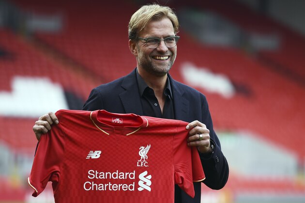 Liverpool's new German manager Jurgen Klopp poses with a team jersey after a press conference to announce his new appointment at Anfield in Liverpool, northwest England, on October 9, 2015. Klopp described his job as 'the biggest challenge' in world football on October 9 following his appointment as the successor to Brendan Rodgers. Former Borussia Dortmund head coach Klopp, 48, was appointed on October 8 on a three-year contract following the dismissal of Rodgers, who was sacked October 4 after three and a half years at the club.  AFP PHOTO / PAUL ELLIS  

RESTRICTED TO EDITORIAL USE. No use with unauthorized audio, video, data, fixture lists, club/league logos or 'live' services. Online in-match use limited to 75 images, no video emulation. No use in betting, games or single club/league/player publications.        (Photo credit should read PAUL ELLIS/AFP/Getty Images)