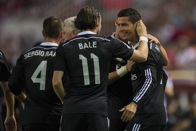 Real Madrid's Cristiano Ronaldo, right, celebrates his goal with Real Madrid's Gareth Bale, left, during a Spanish La Liga soccer match between Sevilla and Real Madrid at the Ramon Sanchez Pizjuan stadium in Sevilla, Spain, Saturday, May 2, 2015. (AP Photo/Andres Kudacki)