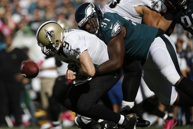 New Orleans Saints' Drew Brees, left, fumbles the ball after a hit from Philadelphia Eagles' Fletcher Cox during the second half of an NFL football game, Sunday, Oct. 11, 2015, in Philadelphia. (AP Photo/Michael Perez)
