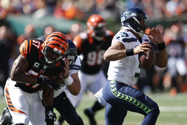 Seattle Seahawks quarterback Russell Wilson, right, runs the ball in the first half of an NFL football game against the Cincinnati Bengals, Sunday, Oct. 11, 2015, in Cincinnati. (AP Photo/Gary Landers)