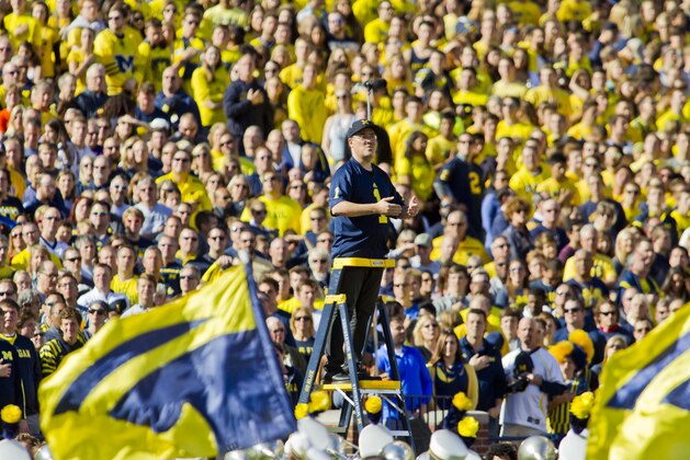 Alan Gilbert, music director of the New York Philharmonic, conducts members of his brass section along with the Michigan Marching Band for a half time performance during an NCAA college football game between Michigan and Northwestern in Ann Arbor, Mich., Saturday, Oct. 10, 2015. (AP Photo/Tony Ding)