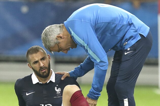 Doctor of France's soccer team, Franck Le Gall, examines Karim Benzema,  as he is injured during the friendly soccer match against Armenia, in the stadium of Nice, southeastern France, Thursday, Oct 8, 2015. Benzema gives up for the next friendly match against Denmark next Sunday. (AP Photo/Lionel Cironneau)